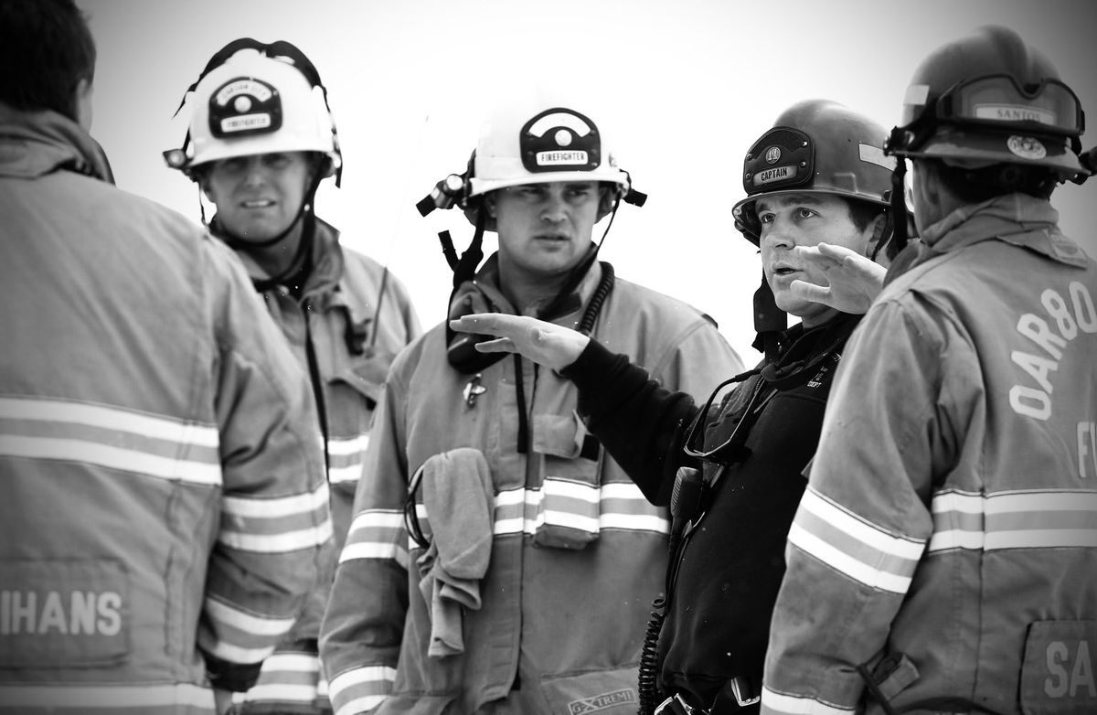 Firefighters in turnout gear and helmets during a training evolution